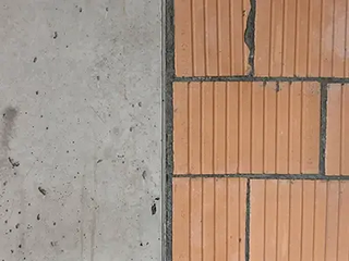 Wandbereich aus Beton trifft auf Ziegelmauerwerk